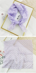 Detail of light purple silk scarf featuring a white crescent moon print and sheer fabric