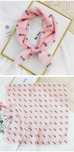 Pink chiffon square scarf with repeating dark blue Chinese characters in a stylish layout