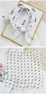 Detail of white cotton linen scarf with black Chinese text print and sheer texture