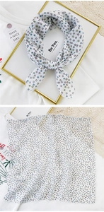 Detail of white cotton linen scarf featuring colorful geometric square patterns and print