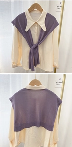 Detail of knitted purple shawl draped over a beige long-sleeve shirt with collar