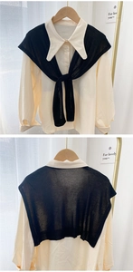 Close-up of black knitted thin shawl draped over a beige long-sleeve collared shirt
