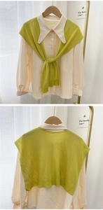 Detail of green knitted shawl and off-white shirt set with rib-knit edge details