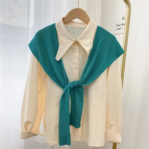 Off-white long sleeve shirt paired with a knotted lake green knitted shawl on a hanger