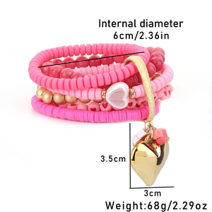 Close-up of pink beaded bracelet layers with a gold heart pendant and size dimensions
