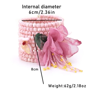 Détail d'un bracelet bohème multicouche avec perles en résine et pompon floral élégant