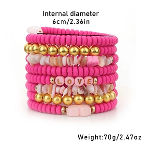 Detail of layered bohemian bracelets with pink polymer clay discs and LOVE heart beads