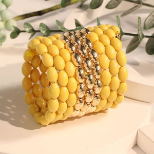 Bohemian multi-layer wrap bracelet with vibrant yellow beads and polished gold accents