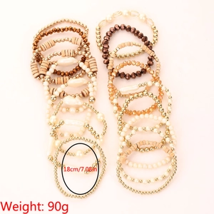 Détail des bracelets multicouches bohèmes avec perles dorées, perles nacrées et en bois