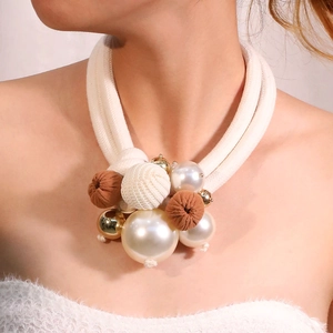 Detail of elegant double-layer necklace with chunky white rope and pearl gold accents