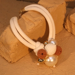 Detail of bohemian double-layer rope necklace with faux pearls and woven beads