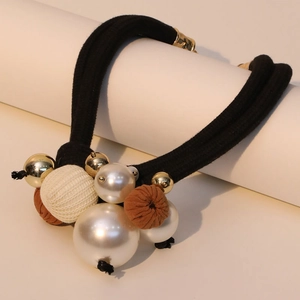 Detail of double-layer hair tie featuring white faux pearls and gold metal beads