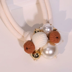 Close-up of double-layer necklace with off-white braided ropes and pearls