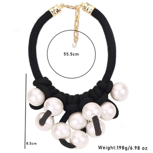Exaggerated braided rope necklace with large white pearl pendant and gold clasp