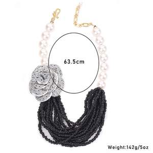 Detail of multilayer pearl necklace with silver flower charm and adjustable S-hook clasp
