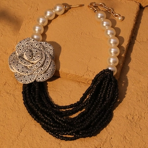 Multi-layer vintage faux pearl necklace featuring a bold black and white camellia flower pendant