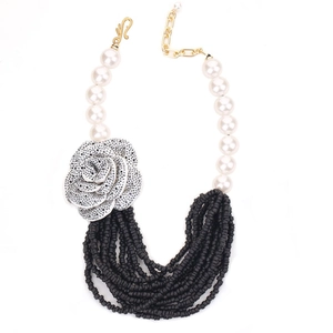 Multilayer necklace with large white pearls, silver rose charm, and black bead tassels