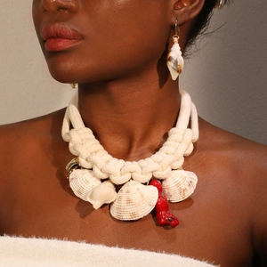 Bohemian woven rope necklace with shell and red coral pendants on female model