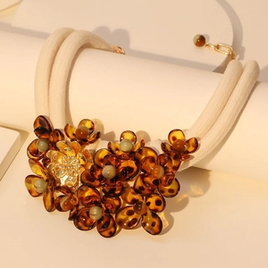 Detail of amber acrylic flower petals with vintage green beads on woven cord necklace