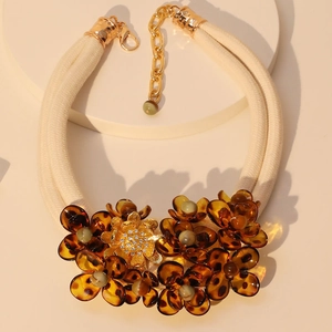 Detail of amber acrylic flower statement necklace with crystal center and ivory cords