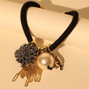 Detail of floral necklace with faux pearls and gold paperclip links on black cord