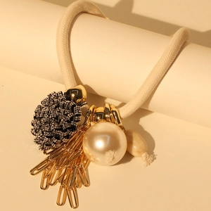 Detail of flower necklace with faux pearl, tassels, and sparkling crystal accents