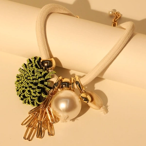 Close-up of pearl flower necklace featuring woven rope and gold paperclip charms