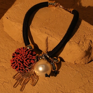Detailed shot of bohemian floral necklace with pearl accents and gold fringe tassels
