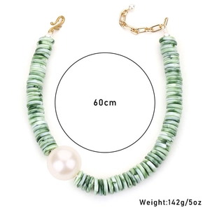 Detail van acryl groene marmeren kralen en een grote witte parel op een 60cm ketting