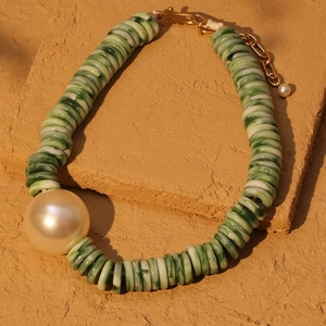 Elegante kralenketting met groene marmeren schijven, witte parel en gouden ketting