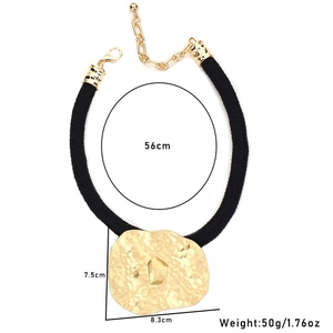 Detailed view of large hammered gold pendant necklace with 56cm black waxed cord