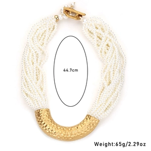 Detail of multi-strand pearl necklace with gold U-shaped hardware and T-bar closure