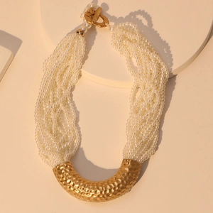 Multi-strand pearl necklace with a curved gold hammered pendant and OT toggle clasp