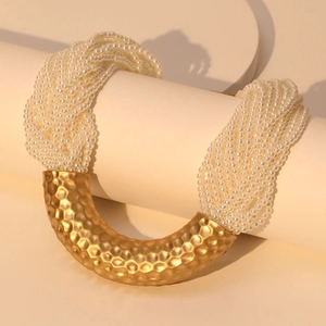 Luxury multilayer pearl necklace with gold U-shaped hammered metal pendant on display