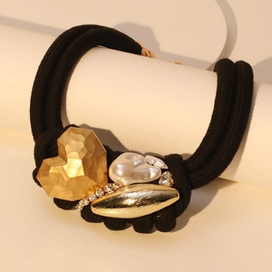 Detail of a braided black elastic bracelet with golden heart, pearl and crystal accents