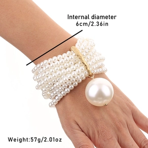 Detail of multi-layer beaded bracelet with oversized pearl pendant and gold accents