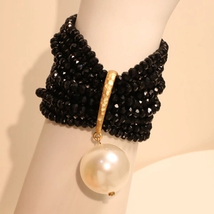 Elegant multi-layer black crystal beaded bracelet with a large white pearl and gold accents