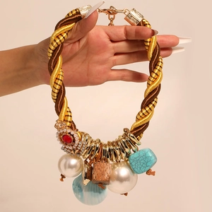 Collier bohème tissé avec fausses perles coquillages et pendentif couronne sur fond blanc