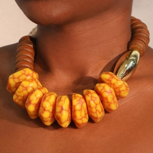 Collier style ethnique avec perles jaunes craquelées et détail doré porté par un mannequin