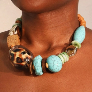 Ethnic necklace with turquoise beads, leopard print accents, and gold details on model