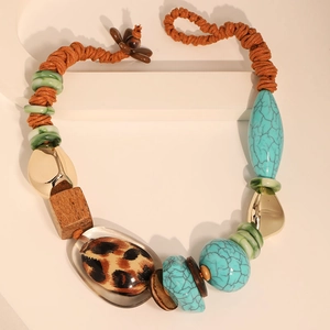 Detail view of ethnic turquoise and leopard print necklace with wooden and metallic beads