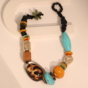 Close-up of leopard print resin and turquoise beads on ethnic braided necklace