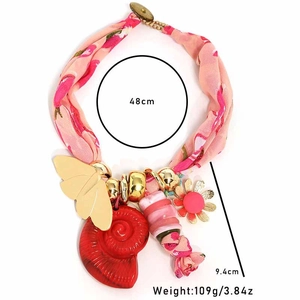 Bohemian floral fabric necklace with butterfly charms and red spiral pendant details