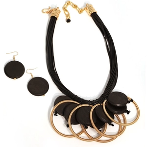 Detail of bohemian necklace and earrings set featuring black wooden disks and gold rings