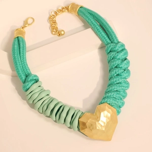 Collier corde vert foncé avec pendentif cœur doré facetté sur socle blanc
