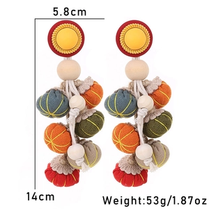 Detail view of handmade bohemian pumpkin tassel earrings with colorful fabric balls