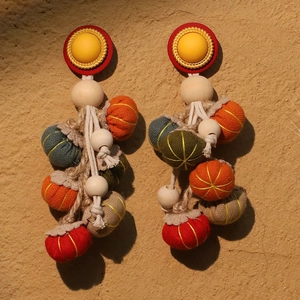 Handmade ethnic pumpkin tassel earrings with colorful fabric beads and rustic texture