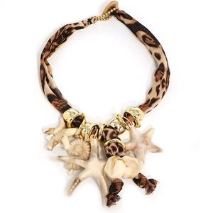Bohemian leopard print fabric necklace with starfish and seashell charms on white background