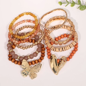 Ensemble de bracelets bohèmes multicouches avec breloques cœur et papillon sur fond blanc