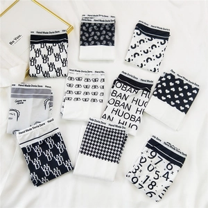 Detail view of nine patterned men's boxer briefs with diverse prints on soft white fabric